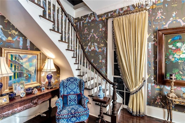 living area featuring stairway, a high ceiling, wood finished floors, baseboards, and wallpapered walls