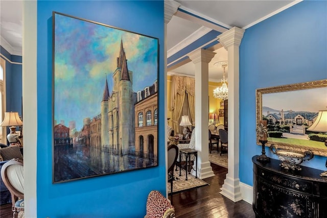 interior space with decorative columns, baseboards, ornamental molding, hardwood / wood-style floors, and a notable chandelier