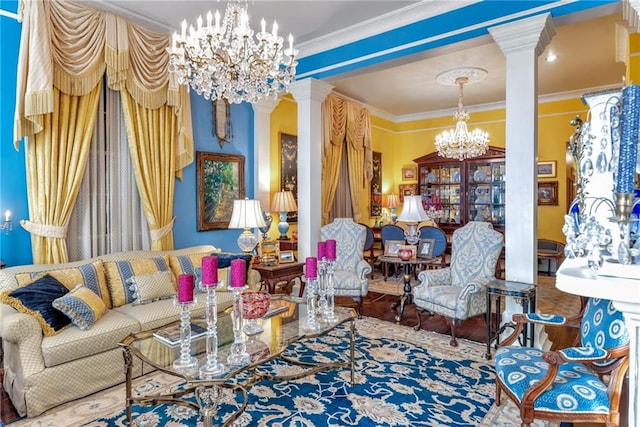 living area featuring a chandelier, decorative columns, and ornamental molding