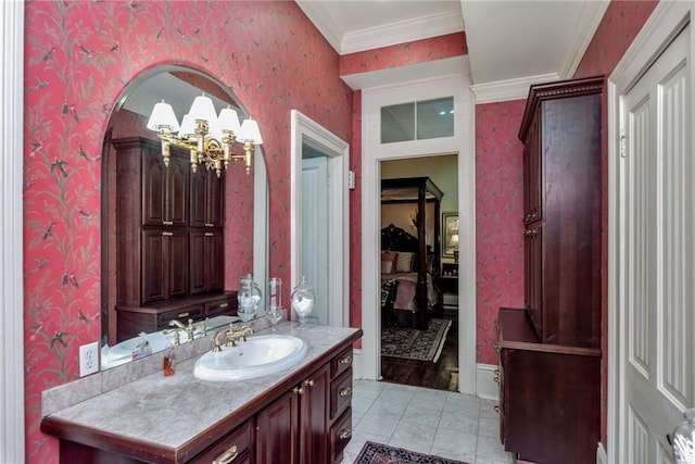 bathroom with vanity, tile patterned floors, wallpapered walls, an inviting chandelier, and crown molding