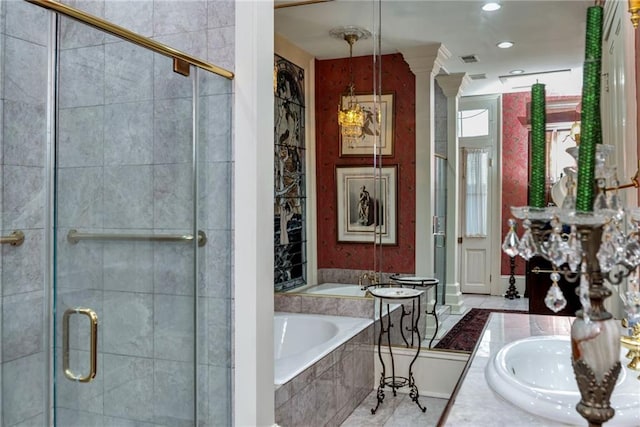 bathroom with a stall shower, a garden tub, vanity, and ornate columns