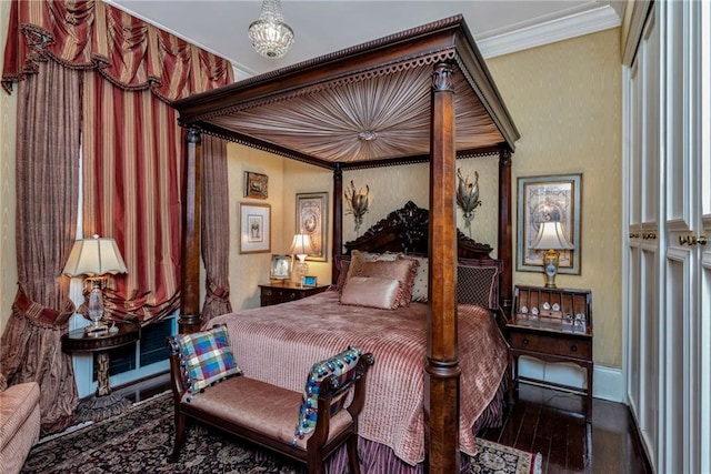 bedroom featuring a chandelier, crown molding, and wood finished floors