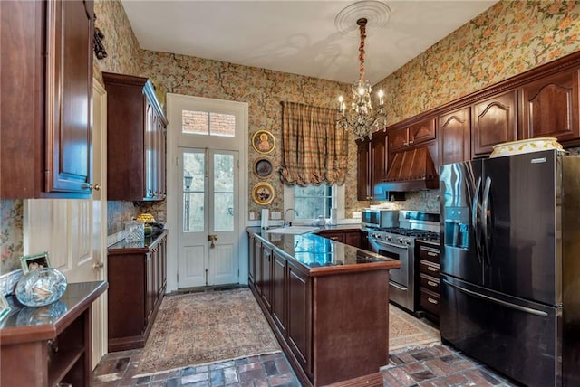 kitchen featuring brick floor, appliances with stainless steel finishes, a sink, premium range hood, and wallpapered walls