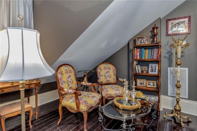 living area with vaulted ceiling and wood finished floors