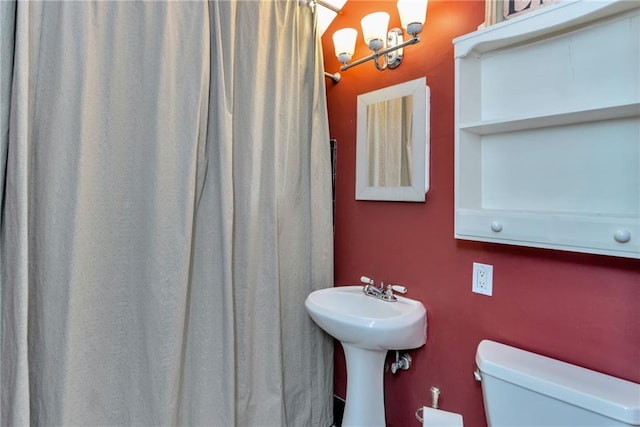 bathroom featuring a shower with curtain, a notable chandelier, and toilet