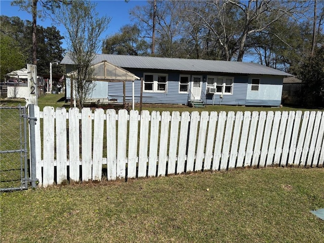 view of front of property featuring metal roof, fence, and a front lawn