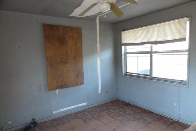 unfurnished room featuring baseboards and a ceiling fan