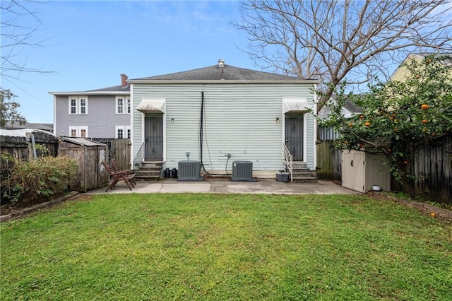 rear view of property featuring entry steps, a fenced backyard, a yard, and a patio