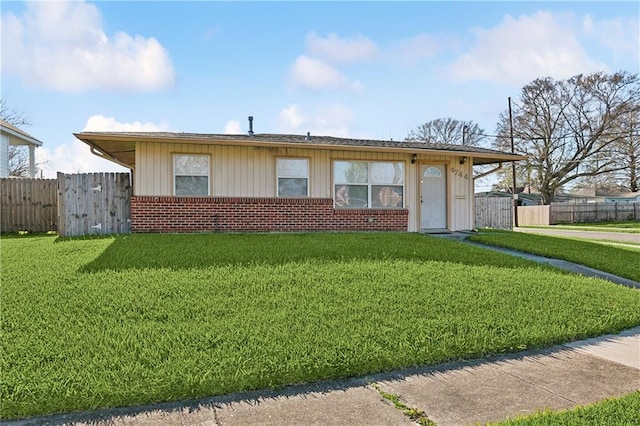 ranch-style home featuring brick siding, a front yard, and fence