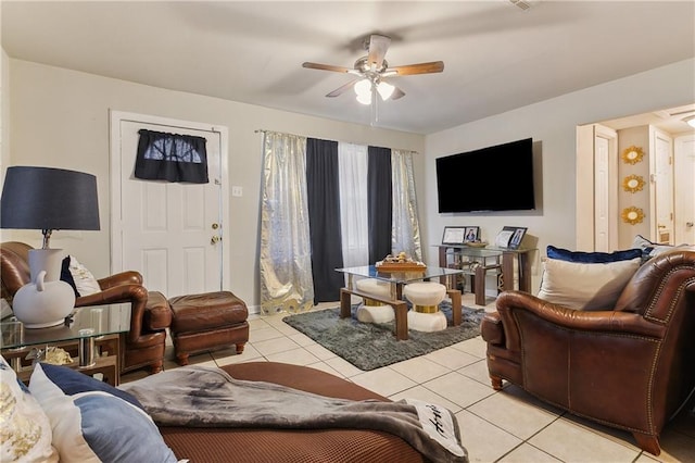 living room featuring light tile patterned floors, ceiling fan, and baseboards