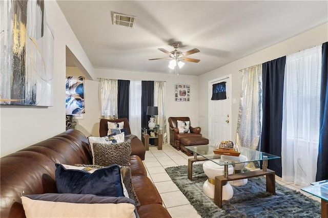 living area featuring light tile patterned flooring, visible vents, and a ceiling fan