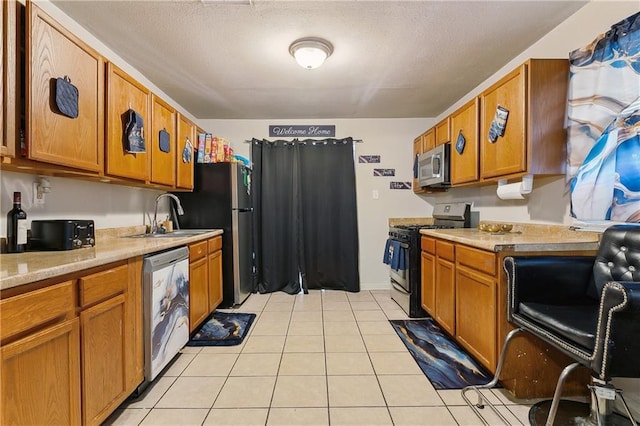 kitchen with brown cabinetry, stainless steel appliances, light countertops, and light tile patterned flooring