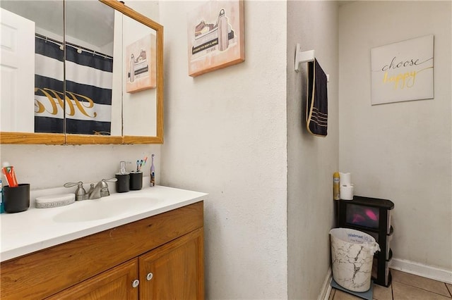 full bath with a shower with curtain, tile patterned flooring, baseboards, and vanity