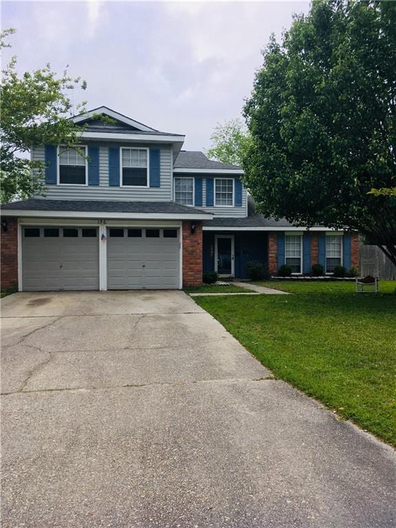 traditional home with an attached garage, brick siding, driveway, and a front lawn