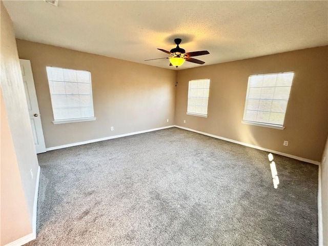 unfurnished room with a textured ceiling, carpet flooring, a ceiling fan, and baseboards