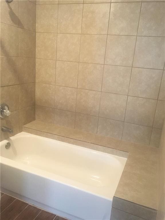 full bath with shower / washtub combination and wood finished floors