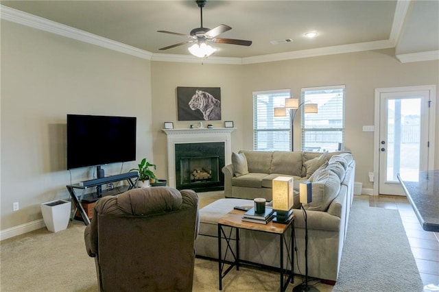 living area featuring ornamental molding, a fireplace, visible vents, and baseboards