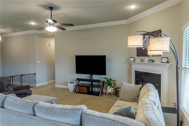 living area with baseboards, carpet, a fireplace, and crown molding