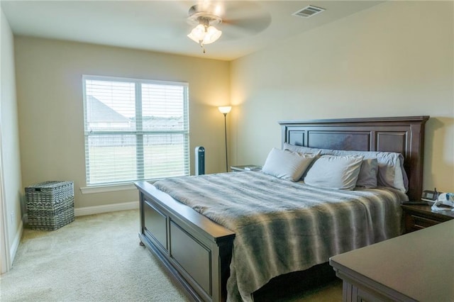 bedroom featuring baseboards, visible vents, a ceiling fan, and light colored carpet