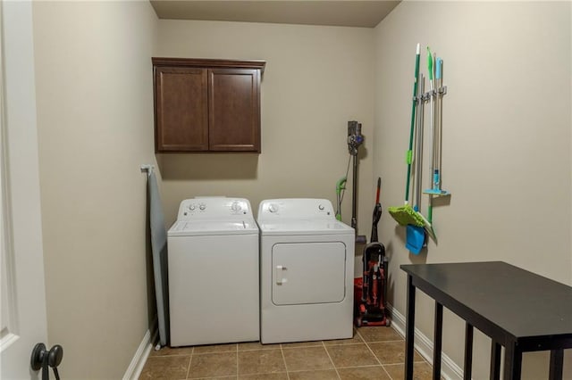 clothes washing area featuring light tile patterned floors, independent washer and dryer, cabinet space, and baseboards