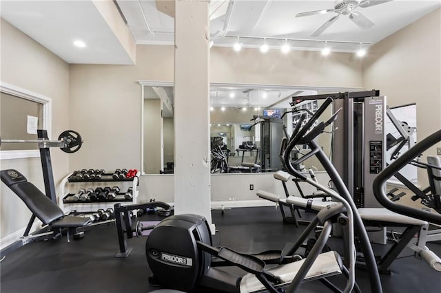 exercise room featuring rail lighting, ceiling fan, and baseboards