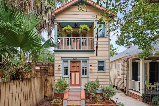 view of front of house featuring fence and a balcony