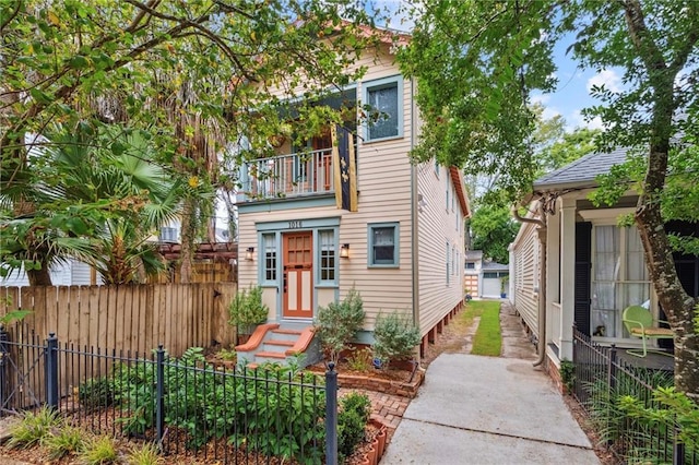 view of front of property featuring a balcony, fence, and entry steps