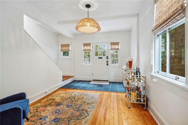 entrance foyer with hardwood / wood-style floors, a wealth of natural light, and baseboards