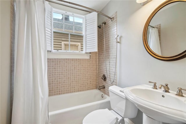 full bathroom featuring a sink, toilet, and shower / bath combo with shower curtain