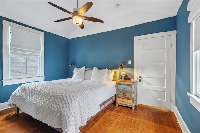 bedroom with lofted ceiling, a ceiling fan, baseboards, and wood finished floors