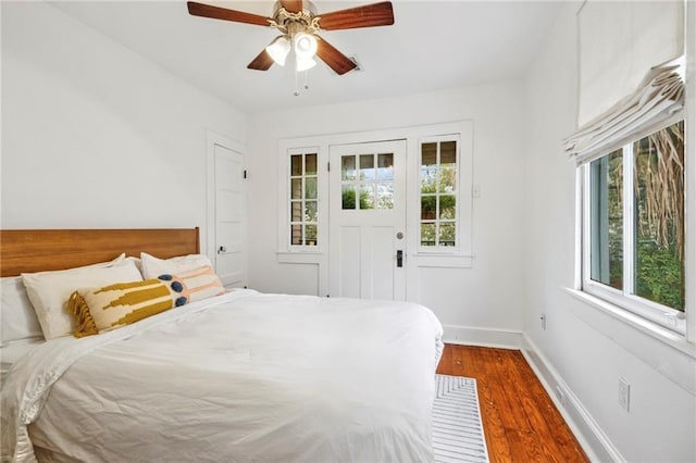 bedroom with a ceiling fan, baseboards, and wood finished floors