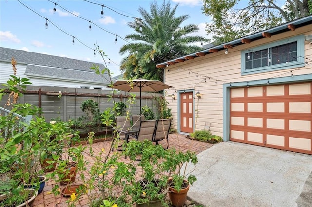 view of patio / terrace featuring driveway and fence