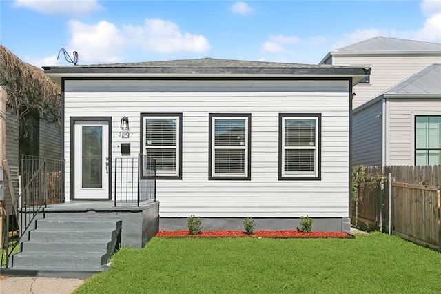 view of front facade with fence and a front lawn