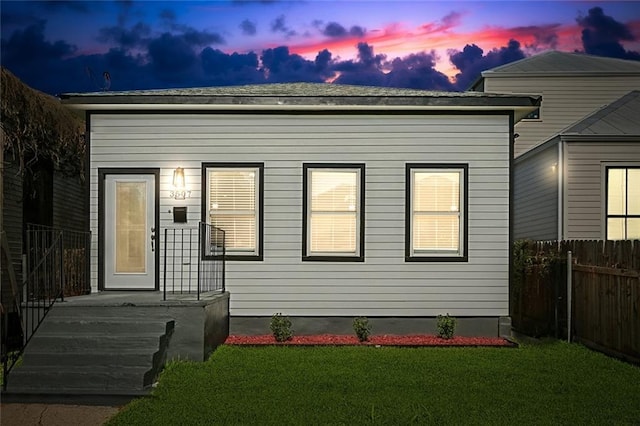 view of front of home with fence and a front lawn