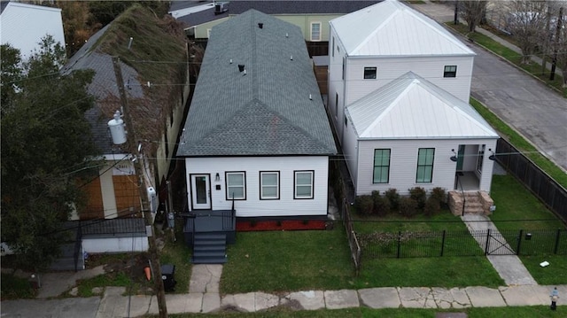 modern inspired farmhouse featuring metal roof, a fenced front yard, and a front lawn