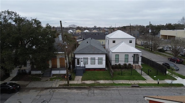 view of front facade with a front yard, fence, and a residential view