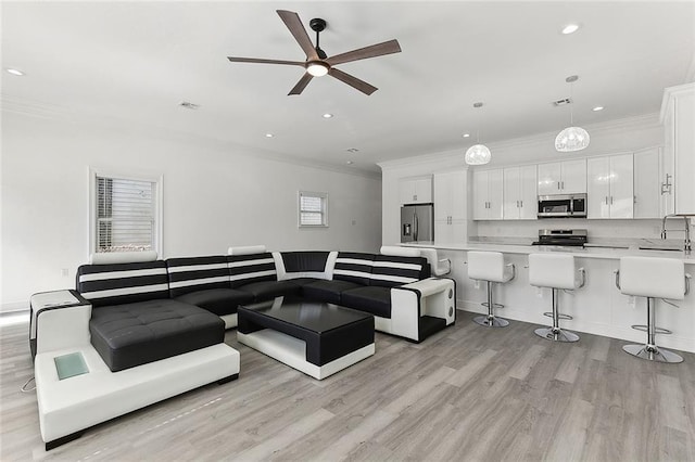 living room featuring crown molding, recessed lighting, visible vents, and light wood-style floors