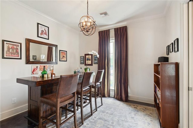 dining space with a bar, baseboards, visible vents, and ornamental molding