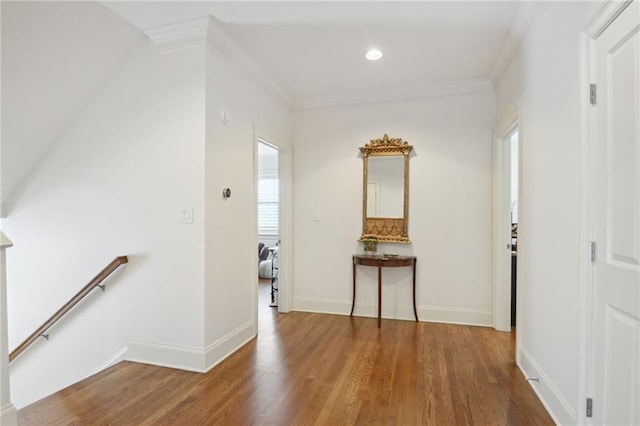 corridor featuring an upstairs landing, wood finished floors, baseboards, and ornamental molding