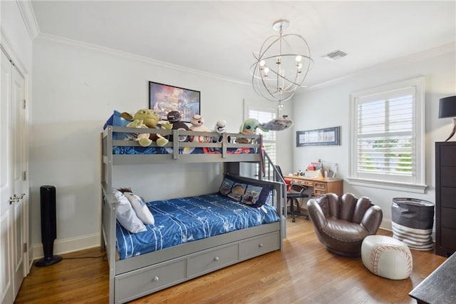 bedroom featuring a chandelier, crown molding, baseboards, and wood finished floors