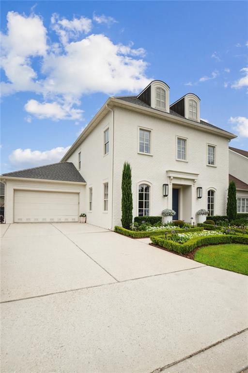 view of front of house with a garage, concrete driveway, and stucco siding