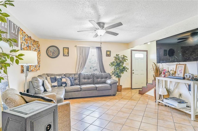 living area featuring stairs, ceiling fan, a textured ceiling, and light tile patterned floors