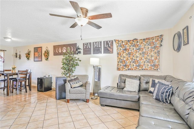 living room featuring ceiling fan, a textured ceiling, and light tile patterned floors