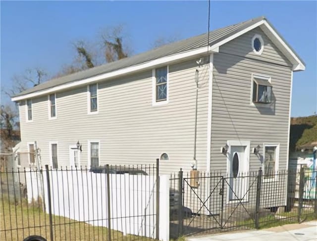 rear view of property featuring a fenced front yard