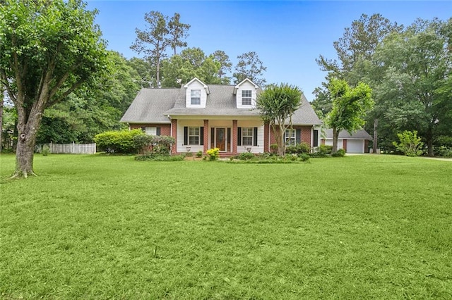 new england style home featuring a front lawn, fence, and brick siding