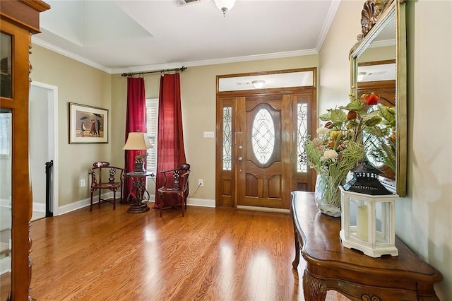 entrance foyer with crown molding, wood finished floors, and baseboards