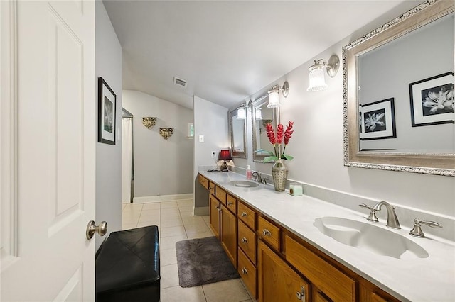 bathroom featuring tile patterned flooring, double vanity, lofted ceiling, and a sink