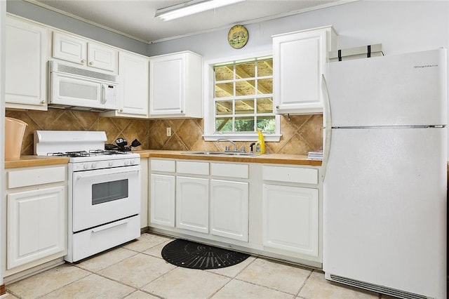 kitchen with a sink, white cabinetry, white appliances, light tile patterned floors, and decorative backsplash