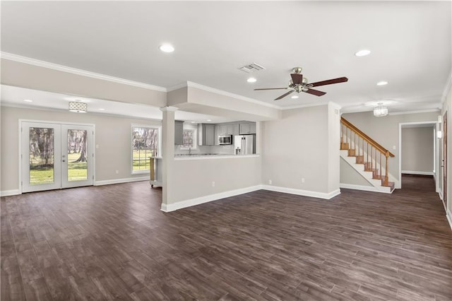 unfurnished living room featuring visible vents, baseboards, stairway, dark wood finished floors, and crown molding