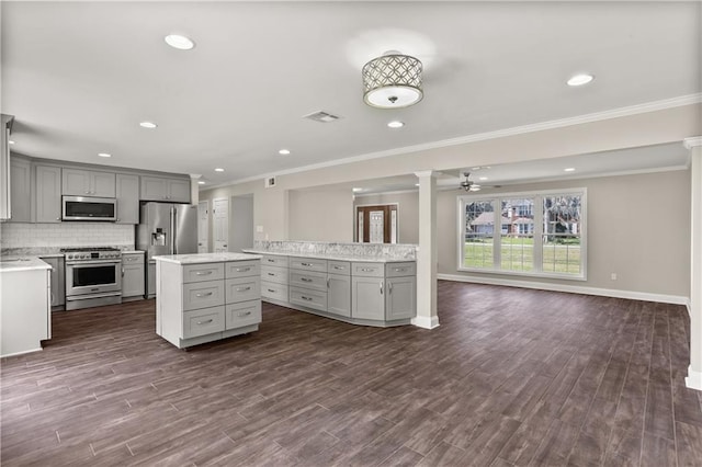 kitchen featuring stainless steel appliances, visible vents, gray cabinets, a center island, and ornate columns